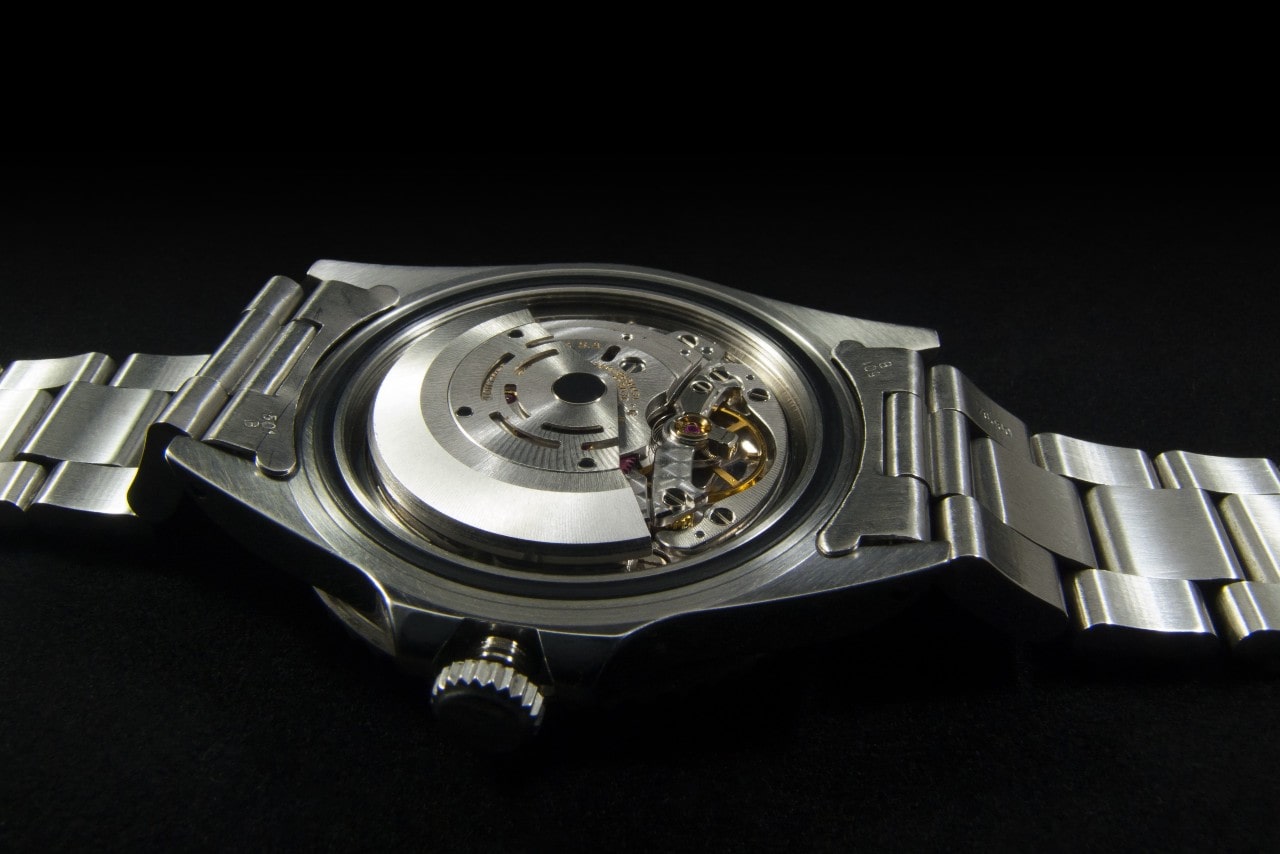 a watch with the back removed to reveal the watch mechanism