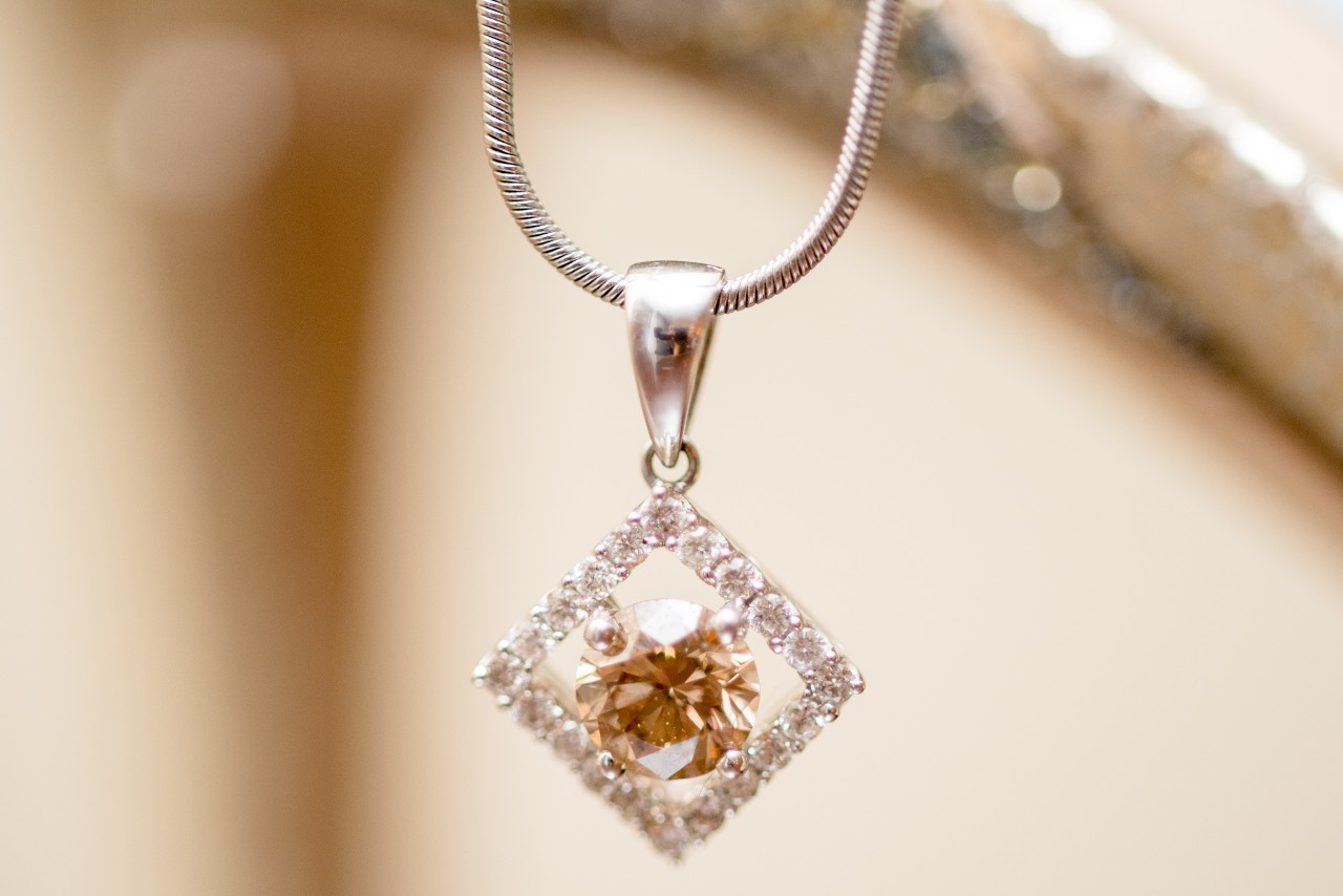 A close-up of a stunning gold pendant necklace with a distinctive center stone.